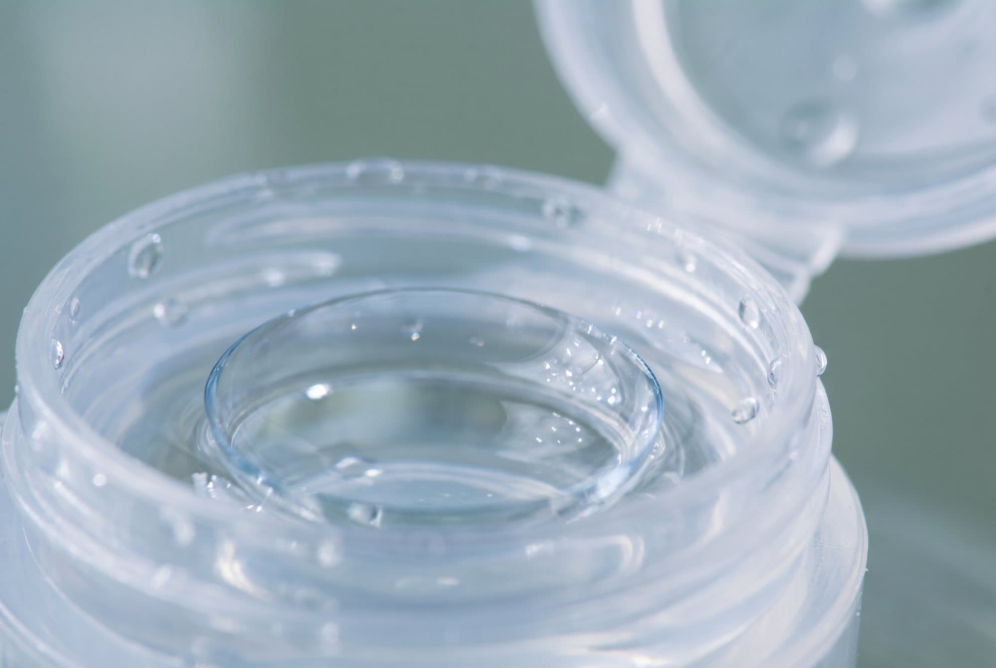 A soft contact lens resting in an open lens case