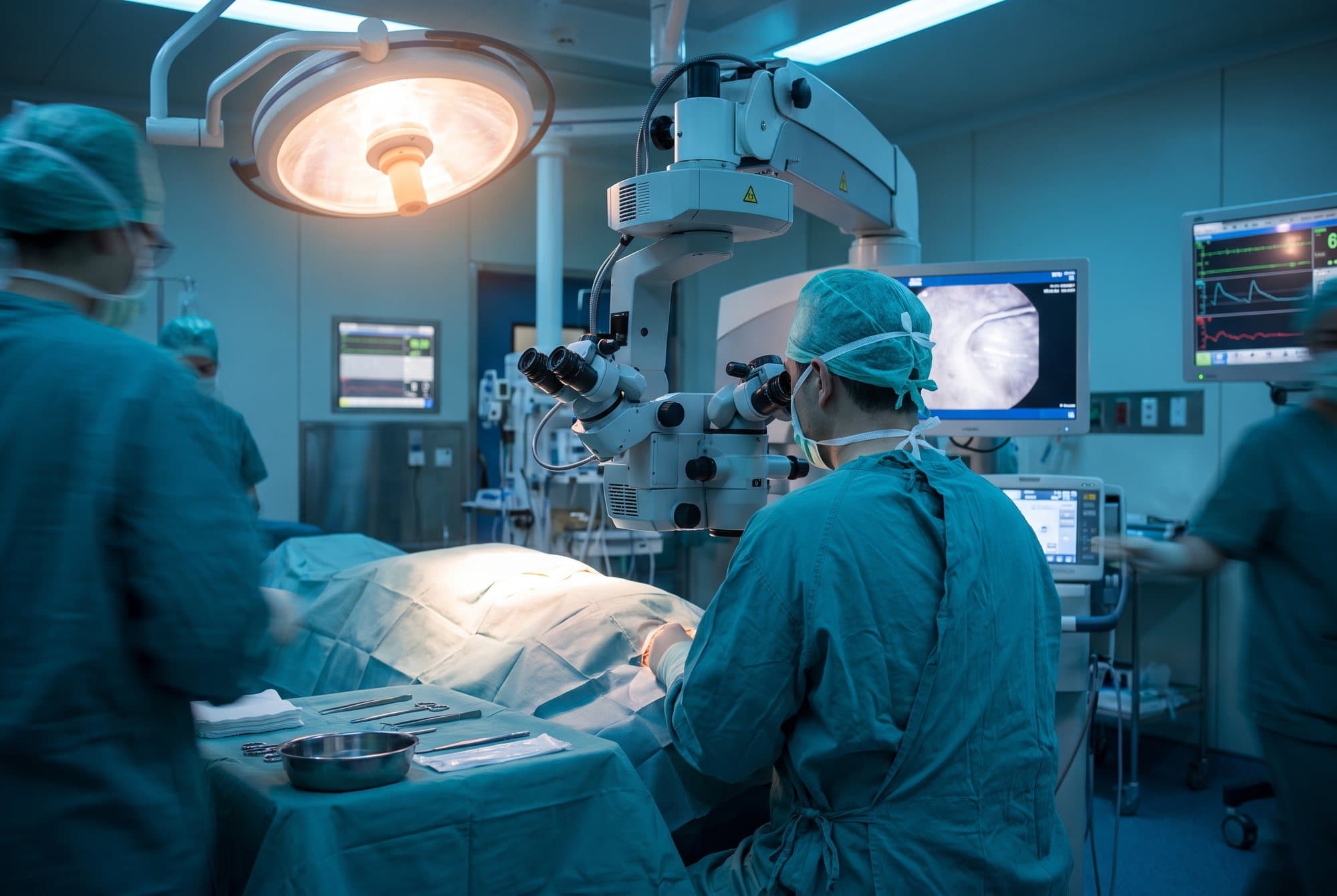 A surgeon at a surgical microscope in an ophthalmic operating theatre